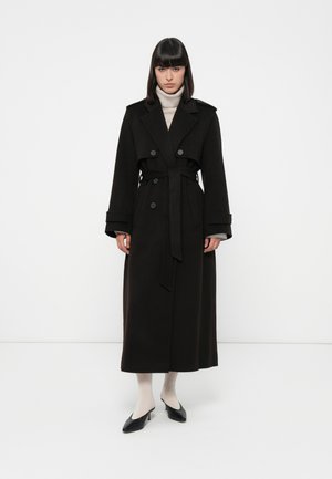Black wool trench coat with a double-breasted design, wide notched collar, belted waist, and long sleeves. Smooth texture and ankle length.