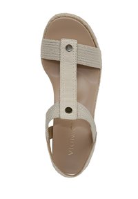 Beige sandal with a woven strap and faux leather accents, featuring a round metal button. Smooth insole and braided sole detail.