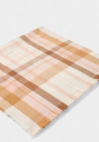 Sciarpa di lana con motivo a quadri nei toni del rosa, marrone e panna. I bordi sono sfrangiati; un piccolo logo è visibile nell'angolo.