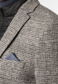 Struktureret grå blazer med et to-tonet mønster. Har en sort quiltet krave og et blåt lommefyr.
