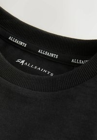 Črna majica s kapuco z rebrastim okroglim izrezom, z belim logotipom "ALLSAINTS" na vratu. Mehka tkanina z gladko teksturo.