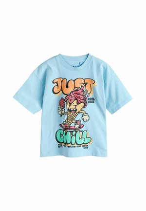 Világoskék póló, melyen egy rajzfilm fagylalt tölcsér szerepel gördeszkán, amint fagylaltot tart, alatta a felirat: "Just Chill" és "Cool Vibes."
