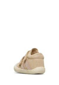 Zapato de ante beige para niño pequeño con punta redonda, correa de velcro, costuras tonales y suela de goma texturizada. Altura de tobillo corta para facilitar el uso.