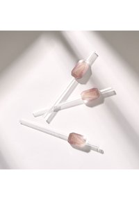 Przezroczyste szklane słomki z heksagonalnymi, różowymi kryształami kwarcu na końcach. Trzy słomki ułożone w przekątnej na jasnej powierzchni, eksponujące klarowność i delikatne akcenty.