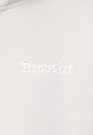 Light gray fabric with a smooth texture featuring embroidered "Dropsize" logo in subtle white stitching.