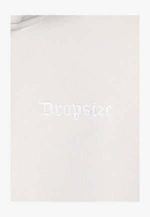 Vaaleanharmaa kangas, jossa on sileä pinta, ja siinä on hienovaraisella valkoisella tikillä kirjailtu "Dropsize"-logo.