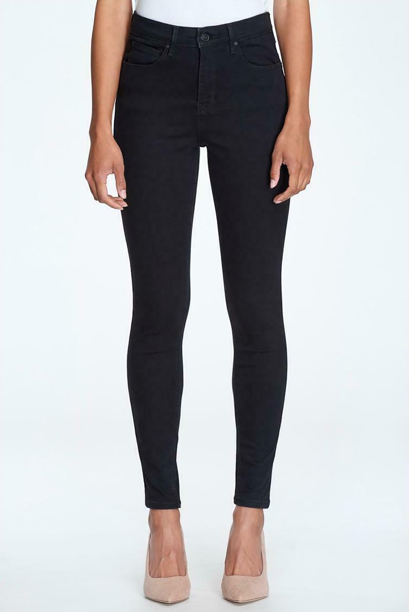 Czarne skinny jeans o wysokim stanie, z dwoma przednimi kieszeniami i gładką teksturą. Noszone z beżowymi szpilkami.