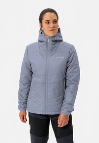 Grijze gewatteerde jas met een hoge kraag en een verstelbare capuchon. Voorzien van een volledige ritssluiting, diagonale stiksels en een logo op de linkerborst.