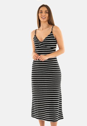 Vestido midi de estampado en blanco y negro, con escote bajo, tirantes finos y una silueta ajustada que se ensancha ligeramente en el dobladillo.
