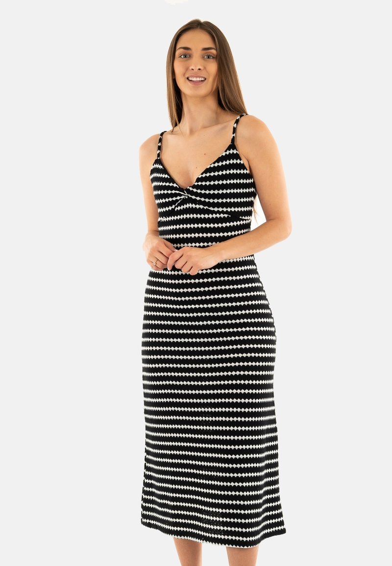 Abito midi a motivi in bianco e nero con scollo basso, spalline sottili e silhouette aderente con un leggero svaso all'orlo.