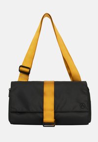 Borsa a spalla di stoffa nera con tracolla e fascia regolabili gialle, dotata di chiusura con cerniera e dettaglio del logo circolare.