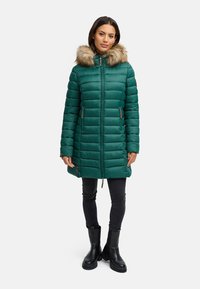 Abrigo acolchado verde con capucha de piel sintética, cierre frontal con cremallera y bolsillos laterales. El abrigo presenta un diseño acolchado y llega a mitad del muslo.