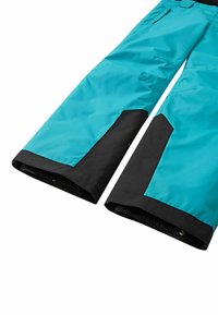 Turkusowe spodnie narciarskie z czarnymi akcentami, o szerokich nogawkach, z elastycznymi mankietami i wzmocnionymi panelami dla większej trwałości.