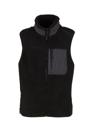 Veste en polaire sherpa noire avec col montant, fermeture éclair à l'avant et poche poitrine zippée côté gauche.