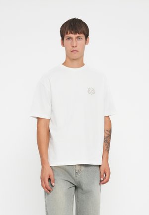Witte katoenen T-shirt met korte mouwen en een ronde halslijn, voorzien van een klein grijs grafisch ontwerp op de linkerborst.