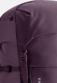 Lila Rucksack mit strukturierter Oberfläche, ausgestattet mit einem seitlichen Schnallenverschluss und verstellbaren Trägern. Hervorstechend durch sein elegantes Design und strapazierfähiges Material.
