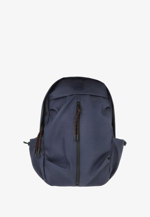 Mochila azul marino hecha de tela duradera, con un zipper frontal y tiradores con acentos rojos, además de bolsillos laterales. Textura suave, forma redondeada.