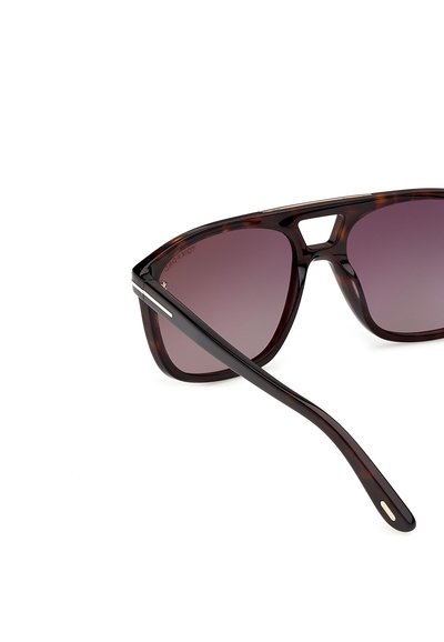 Black and brown tortoiseshell sunglasses with dark tinted lenses and a wide bridge, shown from a close side angle on white background.