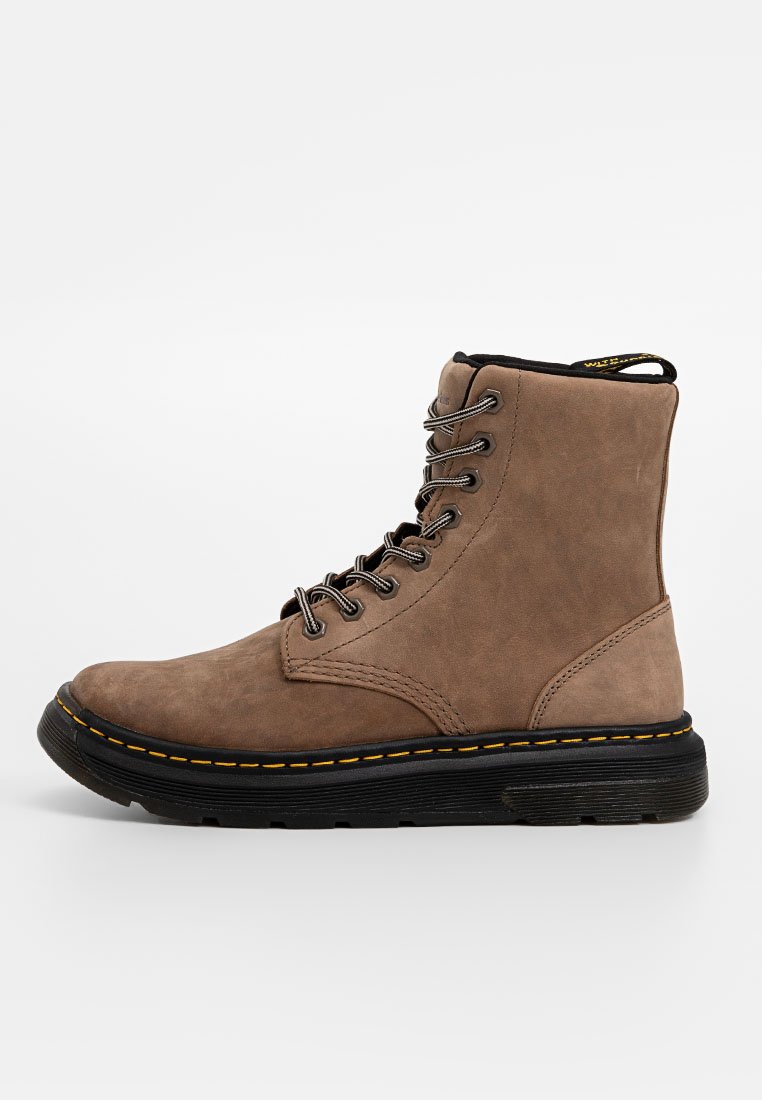 Braune Wildleder-Stiefeletten mit sieben Metallösen, schwarzem Futter, gelben Nähten und einer strukturierten schwarzen Sohle.
