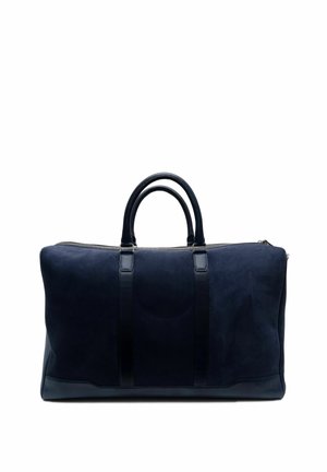 Sac de voyage en suède bleu marine avec des accents en cuir lisse, poignées de transport doubles et fermeture éclair. Lignes épurées et design minimaliste pour les voyages.
