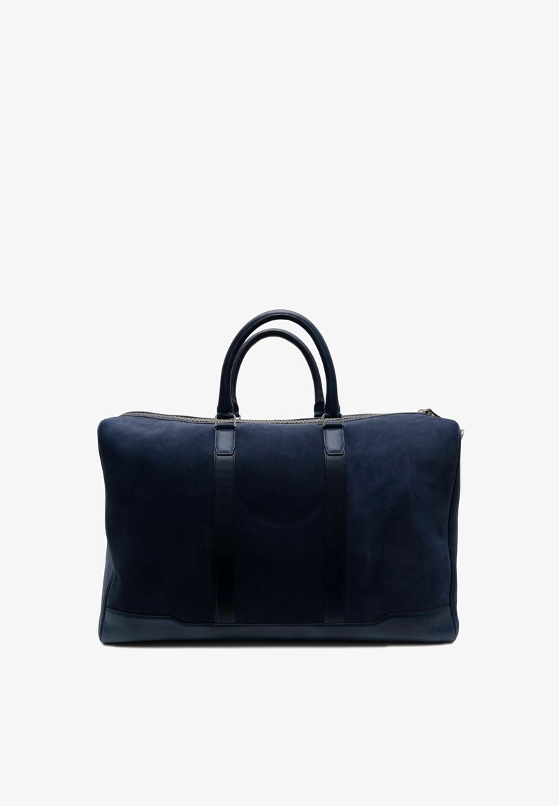 Sac de voyage en suède bleu marine avec des accents en cuir lisse, poignées de transport doubles et fermeture éclair. Lignes épurées et design minimaliste pour les voyages.