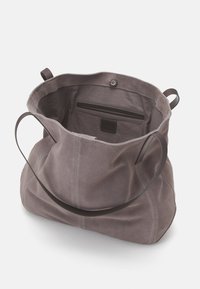 Graue Wildleder-Handtasche mit weicher Textur, weitem Öffnungsbereich und braunem Ledergriff. Verfügt über ein Reißverschlussfach und eine Innentasche zur Organisation.