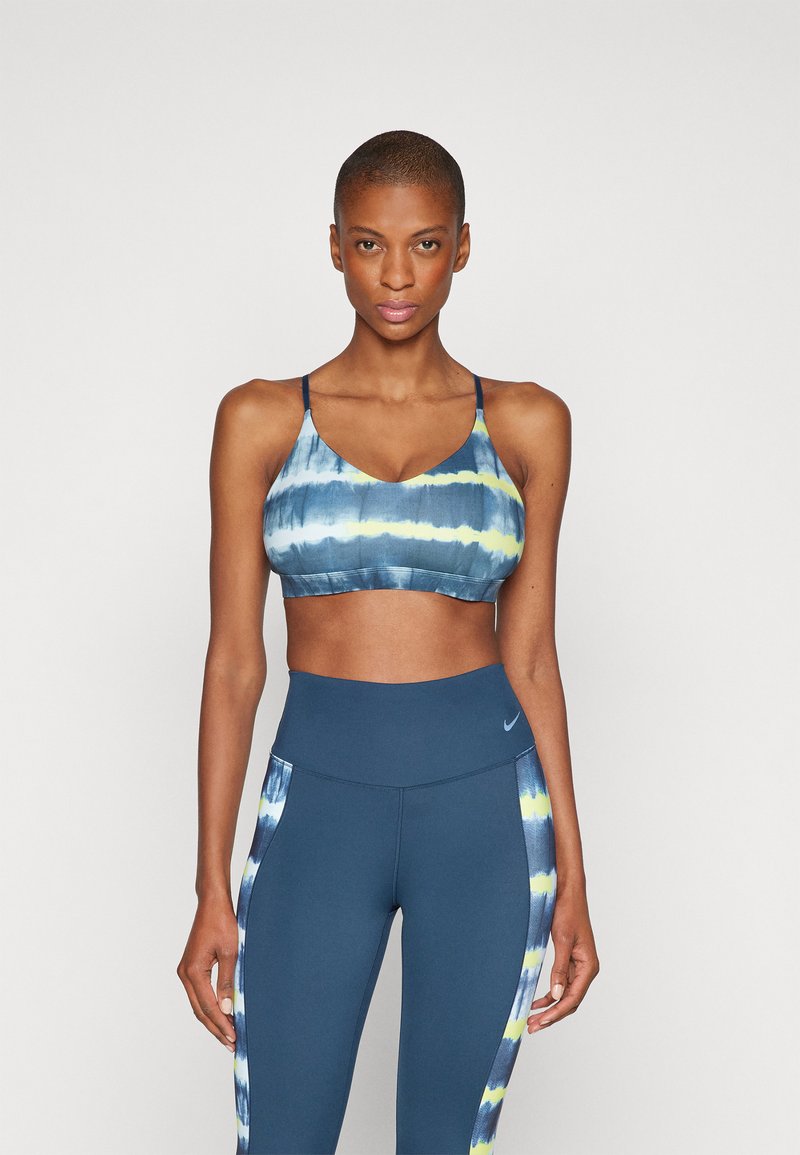 Sutiã desportivo multicolorido com efeito tie-dye, com decote em forma de gota e alças finas, emparelhado com leggings azuis de cintura alta com detalhes em efeito tie-dye nas laterais.
