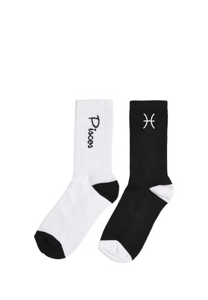 Une chaussette blanche avec le texte « Poissons » et des accents noirs, une chaussette noire avec le symbole du zodiaque Poissons blanc et des accents blancs, toutes deux côtelées et de longueur mi-mollet.