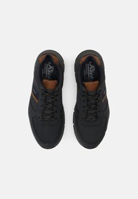 Black athletic shoes with a smooth synthetic upper, contrasting brown accents, textured laces, and cushioned soles for comfort.
