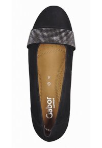 Chaussure plate noire avec semelle intérieure rembourrée beige, ornée d'une bande de petits strass près de l'embout rond.