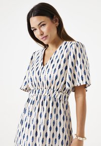 Blau- und cremefarbendes gemustertes Kleid mit kurzen Ärmeln, V-Ausschnitt und gerafftem Taillendetail. Enthält verlängerte Formen in vertikaler Anordnung.
