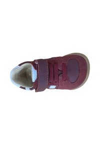 Zapatilla maroon para niño con cierre de Velcro, cordones, materiales de ante y cuero, y suela de goma color beige claro, vista desde arriba sobre un fondo blanco.