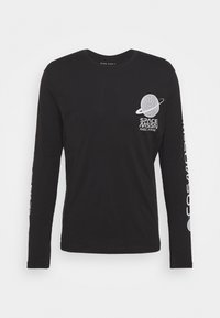 Långärmad svart bomullsskjorta med en vit grafik av en planet och texten "SPACE MISSION NGC 2346" tryckt på framsidan och ärmen.