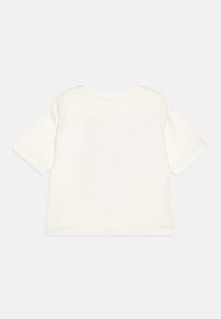 Camiseta de algodón off-white de manga corta y cuello redondo. Presenta un corte relajado y un detalle de costura mínima en el cuello y el dobladillo.