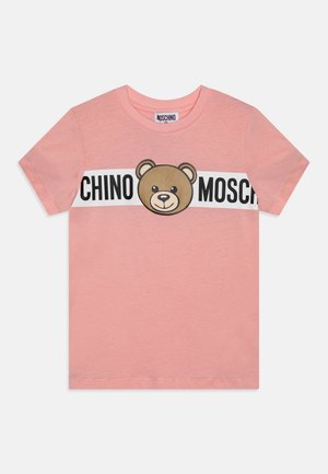 Maglietta di cotone rosa con grafica di un orso marrone e la scritta "CHINO MOSCHINO" in grassetto nero. Maniche corte e scollo rotondo.
