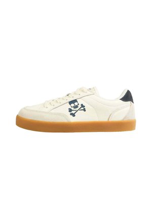 Baskets en suede blanches avec une semelle en caoutchouc marron, arborant un logo de tête de mort et os croisés bleu marine sur le côté, et un accent de talon noir.