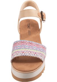 Platform sandal with a beige adjustable strap, multi-colored geometric patterned band, tan suede footbed, and white streaked sole.
