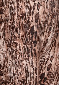 Bruine en beige gestreepte leggings met een textuur van slangenhuid, voorzien van donkere schubben en lineaire markeringen.