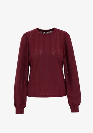 Bordó blúz hosszú, légies ujjakkal. Texturált anyagból készült, cikkcakk mintával. Kerek nyakkivágás és szűk mandzsetták.