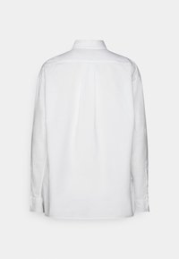 Vit långärmad skjorta med klassisk krage, knappade manschetter, bakveck och sidofickor. Tillverkad av ett smidigt, lättviktsmaterial.