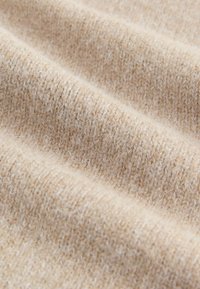 Beige kötött anyag, puha, textúrált felülettel, finom tónusváltozásokkal és szőtt mintázattal. Ideális kényelmes ruhákhoz.