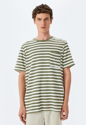 Camiseta de manga corta a rayas verdes y blancas con cuello redondo y bolsillo frontal, confeccionada en tela texturizada. Diseño de corte regular.