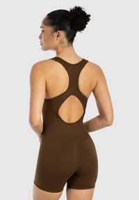 Brun, rippad bodysuit med figurnära passform, racerback-stil och nyckelhålsdetalj bak. Korta ben och slät textur.