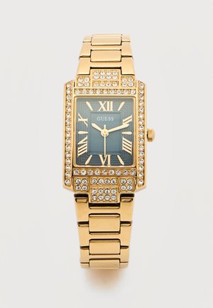 Ceas de mână dreptunghiular cu ton auriu, față albastră, cifre romane, accente de cristal în jurul ramei și al curelei, cu logo-ul "GUESS" pe cadran.
