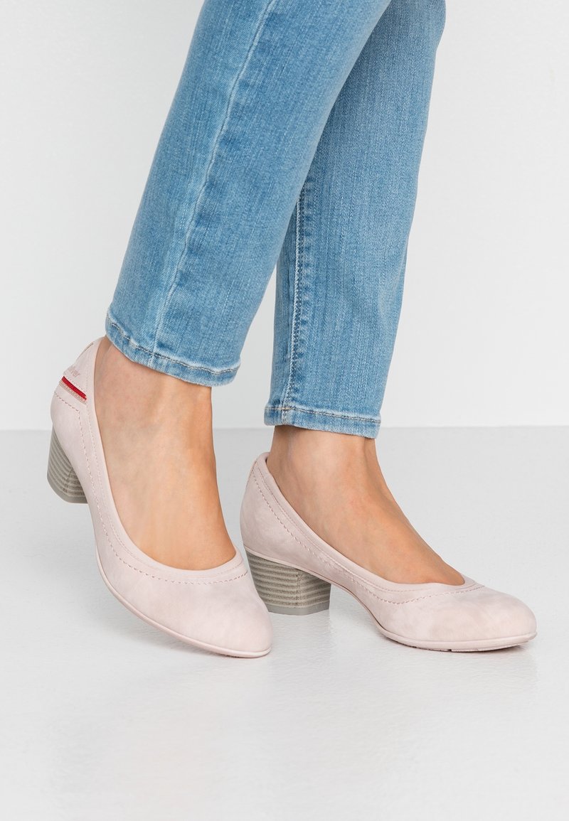 Světlé růžové kožené lodičky s kulatou špičkou, šitými detaily a texturovaným blokovým podpatkem. Nosené se světlými modrými džíny.