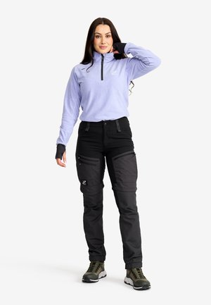 Light purple fleece half-zip top paired with black cargo pants featuring multiple pockets. Olive green ankle boots complete the outfit.