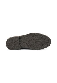 Suela de zapato negra con superficie texturizada, mostrando surcos y patrones, aislada sobre un fondo blanco.