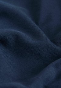 Marineblauer Stoff mit glatter Textur und leichter Dehnbarkeit. Sichtbares feines Strickmuster und weicher Fall. Ideal für Kleidung oder Polsterung.