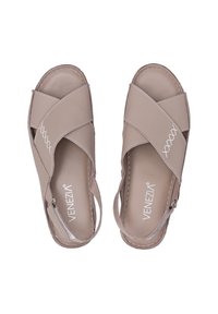 Beige korsrem-sandaler med en glat læderfinish, der har hvid syning og en lynlås bagpå for nem påtagning.