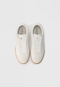 Witte leren en suède sneakers met een gladde afwerking, voorzien van een vetersluiting en een gestructureerde gumrubberen zool. Minimale branding aan de binnenkant.